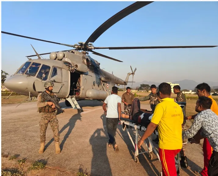 Soldiers and rescuers carry an injured person to an Air Force helicopter